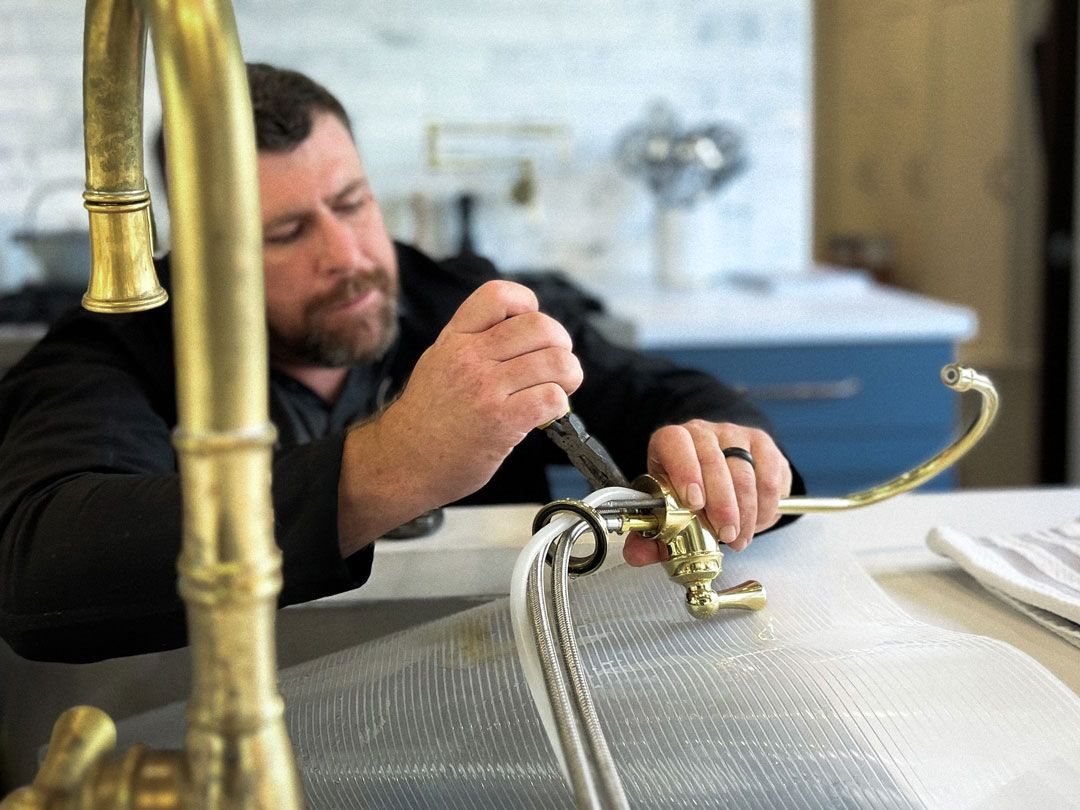 Plumber adjusting a brass faucet